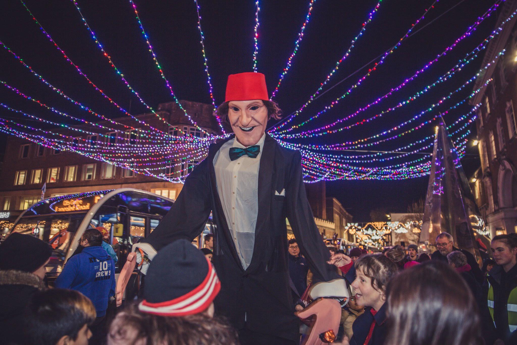 A giant Tommy Cooper puppet under Christmas lights in Exeter city centre.