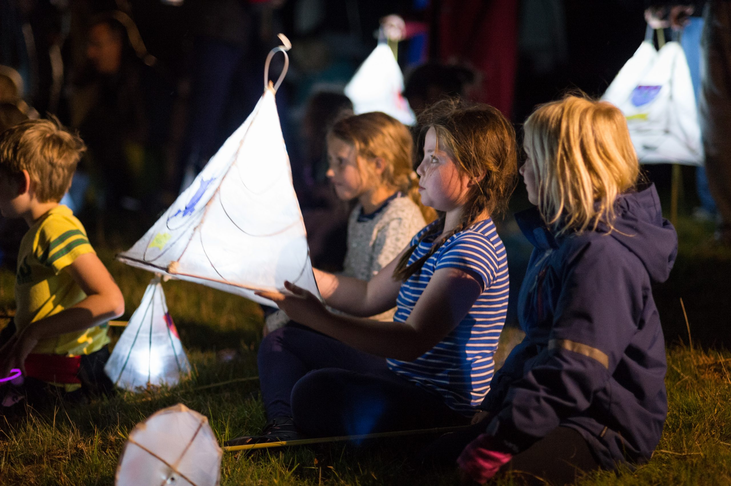 A child stares into her handmade lantern.