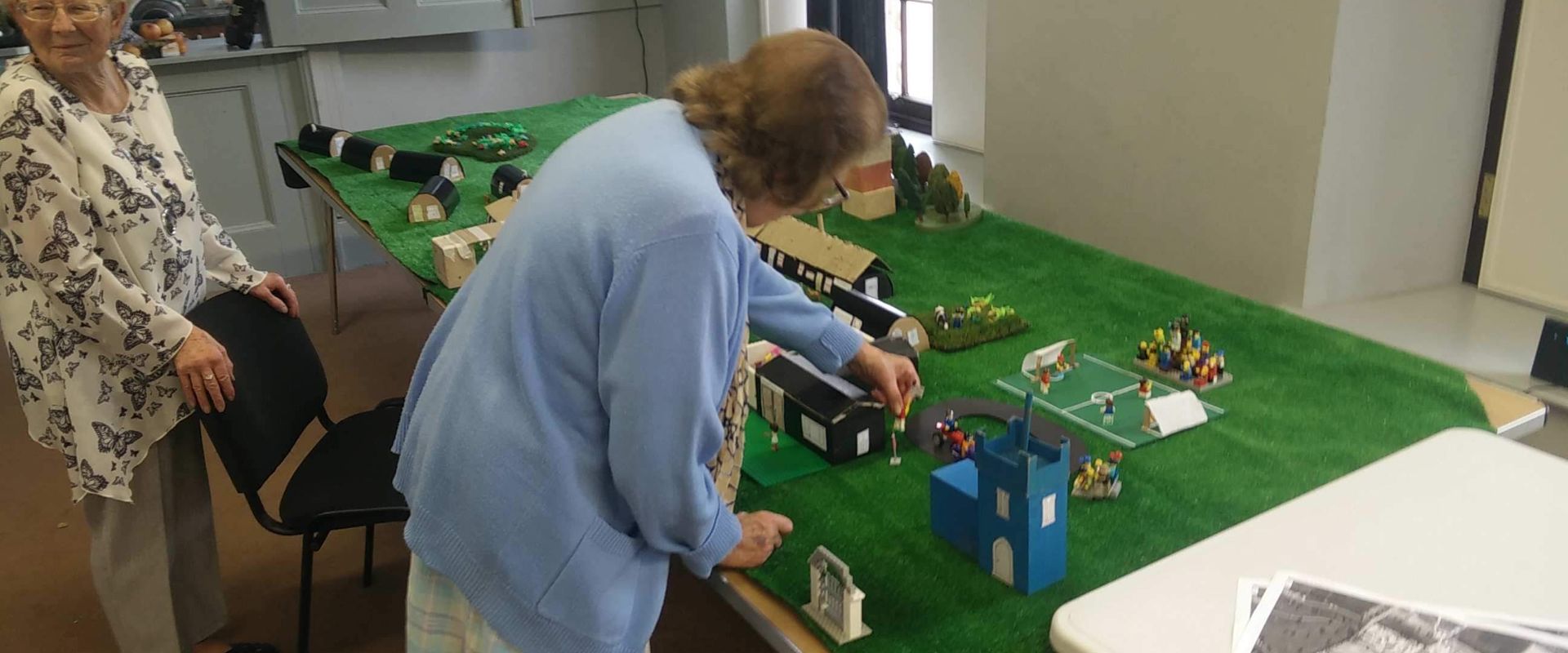 Workshop participant puts the finishing touches to a replica of their old village.