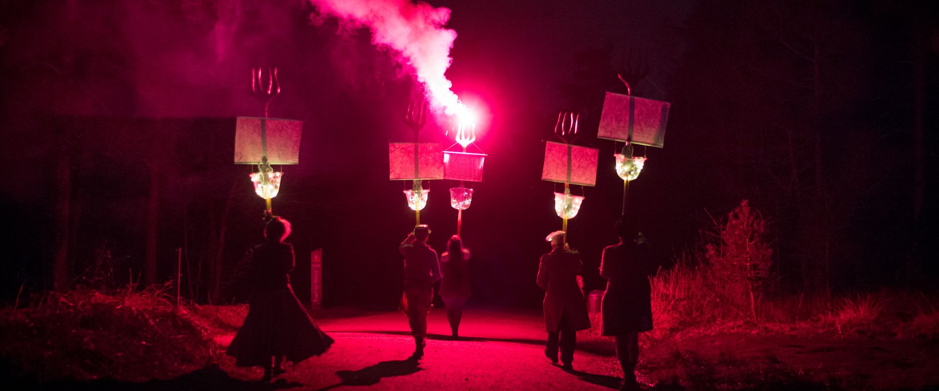 The Bonnet Maker, The Butcher, Isabelle, The Baker, and The Banker march off into the night. They hold their giant forks aloft, the way lit by a red flare.