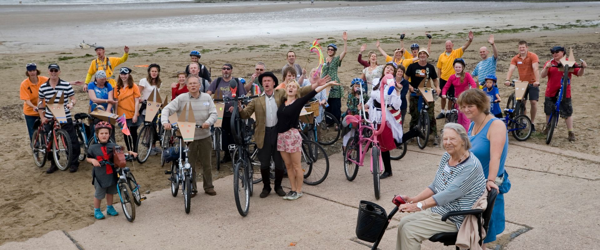 The audience and crew gathered at the end of Don Quixote by Bicycle, on a beach, celebrating the end of their adventure together.