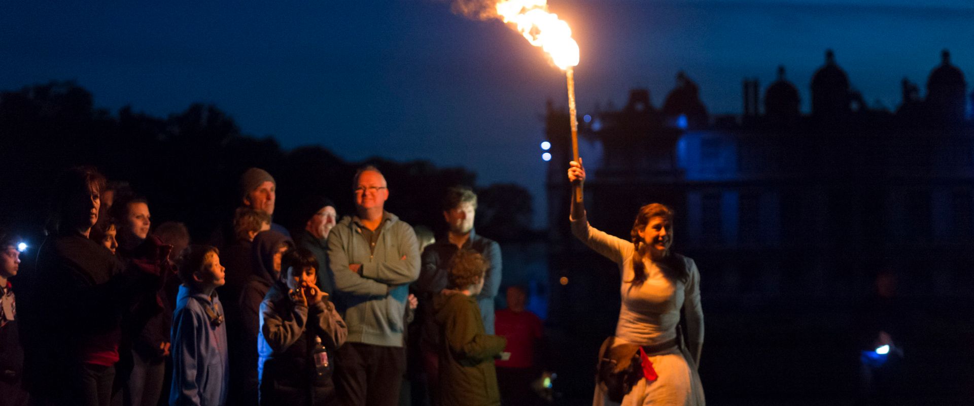 Red Riding Hood, protecting the audience, holds above her head a flaming torch.